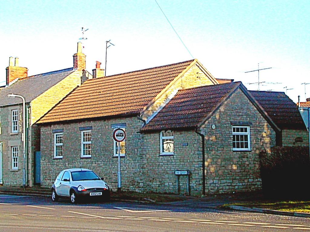 a car parked in front of a brick building at Middle Farm Villa B&B in Wellingborough