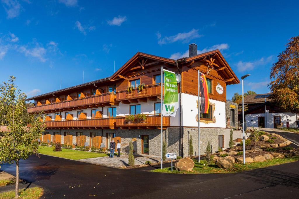 a large building with a wooden roof at Steig-Alm Hotel Superior in Bad Marienberg