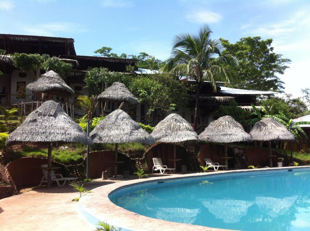 un complejo con piscina y sombrillas en Madera Labrada Lodge Ecologico, en Tarapoto