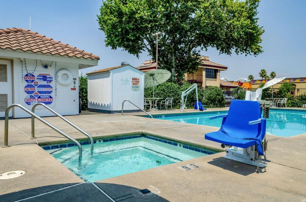 una silla azul sentada junto a una piscina en Motel 6 Oakdale, Ca, en Oakdale