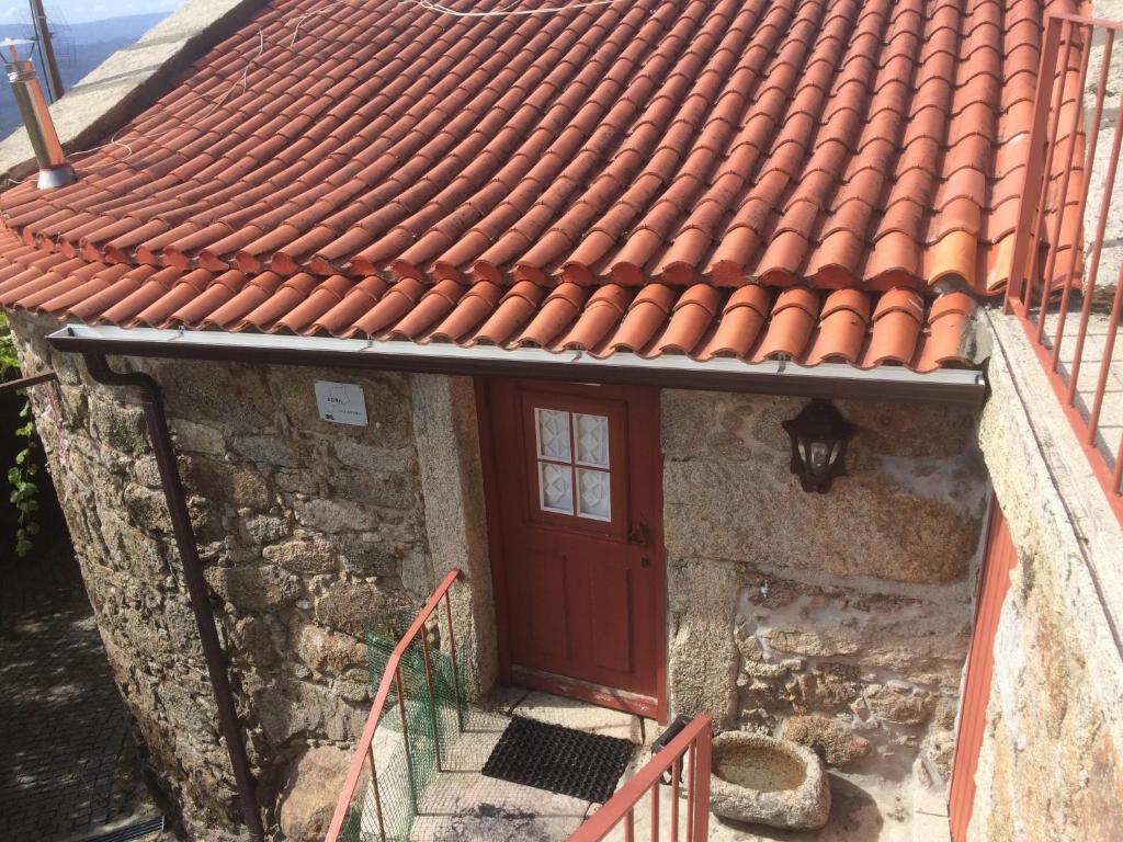 een huis met een rood dak en een deur bij Casa Nova de Germil in Ponte da Barca