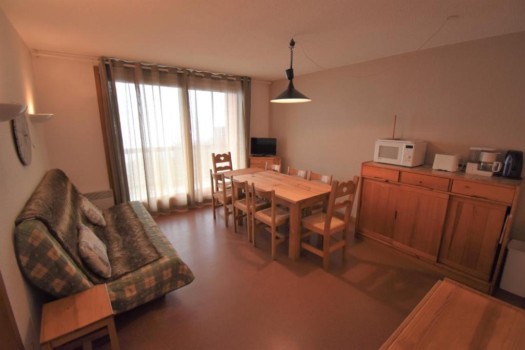 ein Wohnzimmer mit einem Esstisch und einer Küche in der Unterkunft VAUJANYLOCATIONS - Cochette I Apt 14 in Vaujany