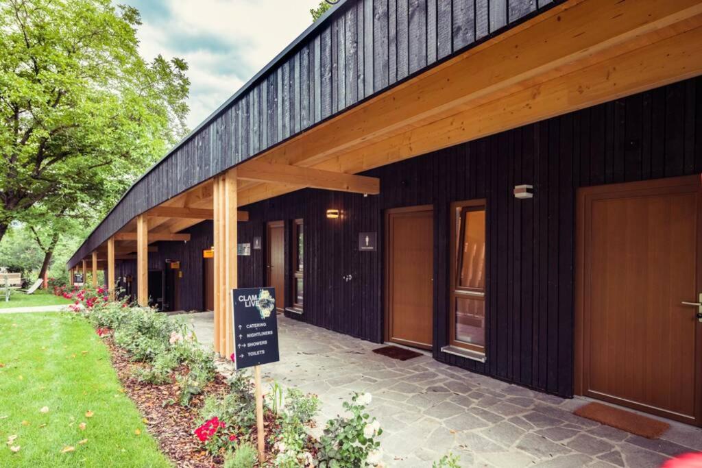 a black building with a sign in front of it at ClamLive Lodge in Klam