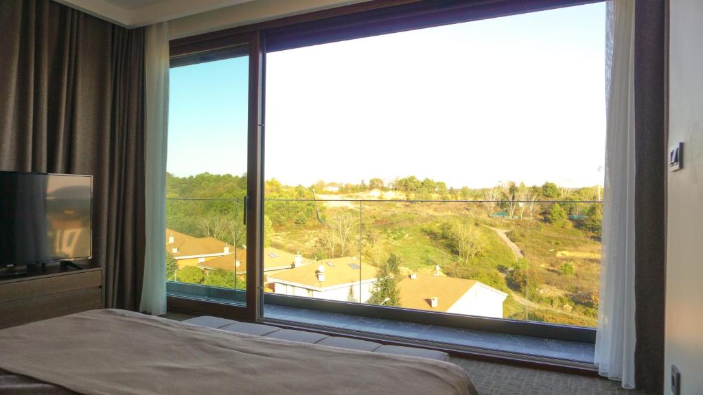 a bedroom with a large window with a view at Selini Hotel İstanbul Airport in Istanbul