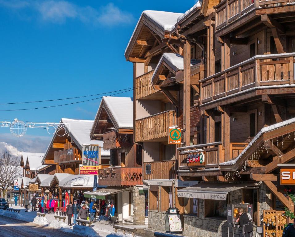 a street in a ski resort with wooden buildings at Alaska Lodge in Morzine