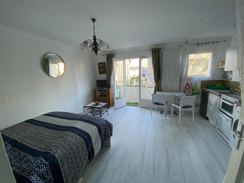 een slaapkamer met een bed en een tafel en een keuken bij Naïades 2 in La Baule