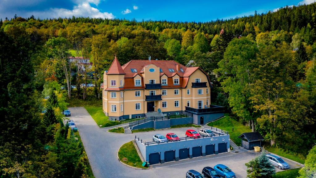 an aerial view of a large house with cars parked in a parking lot at Apartamenty Sun & Snow Karpacz Sucha in Karpacz