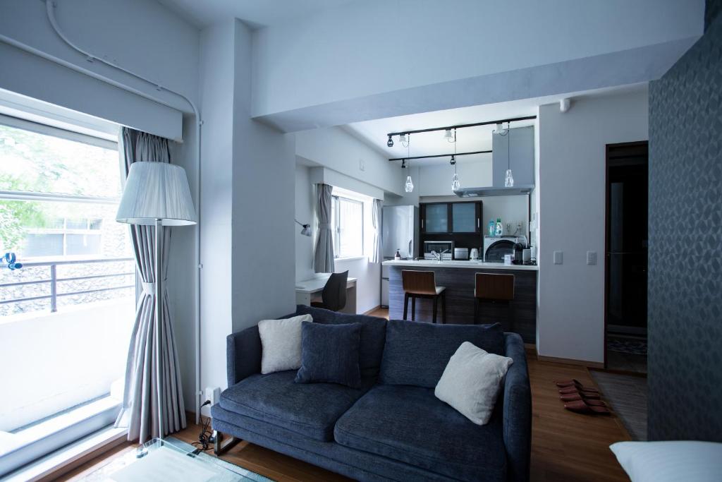 a living room with a blue couch and a kitchen at NIYS apartments 03 type in Tokyo