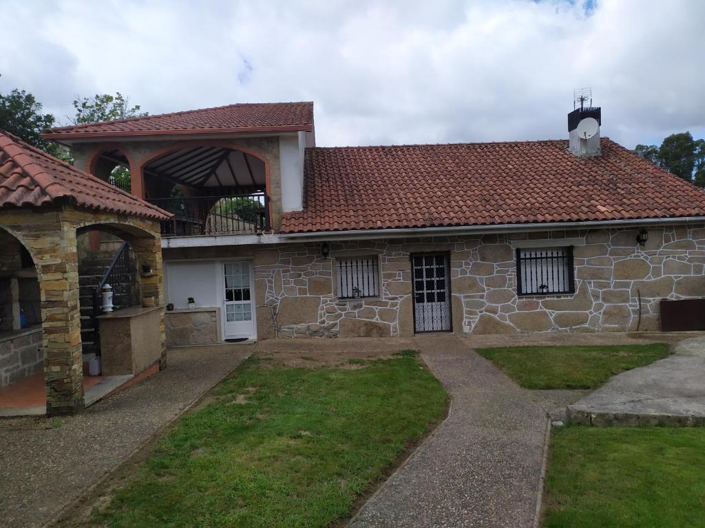 ein großes Steinhaus mit einem Dach und einem Hof in der Unterkunft Casa Garabullo in Cepeda