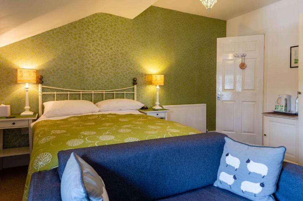 a bedroom with a bed and a couch at The Lakes B and B in Ambleside