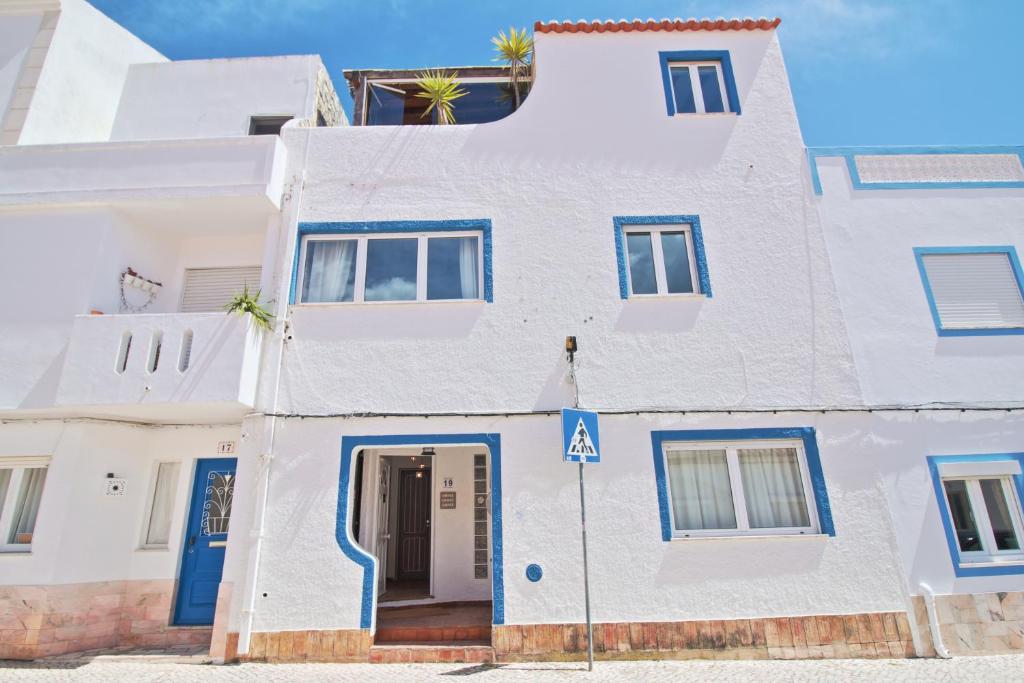 
a white and blue building with two windows at Guesthouse Peixinho in Burgau
