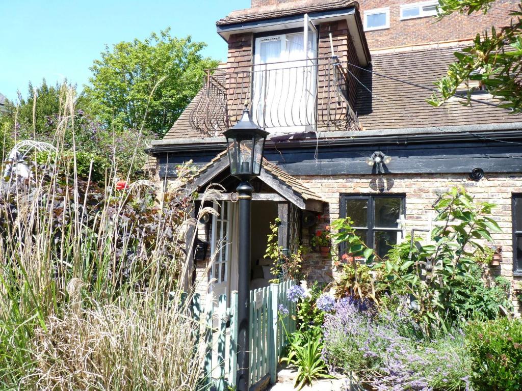 a house with a green gate and a balcony at Secret Garden Hideaway For Adults in Eastbourne