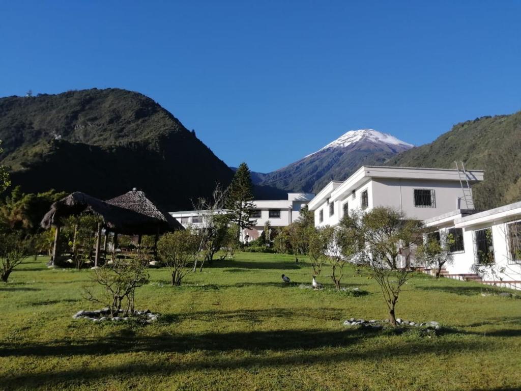 un edificio blanco con montañas en el fondo en Casa del Peregrino Santo Thomas en Baños