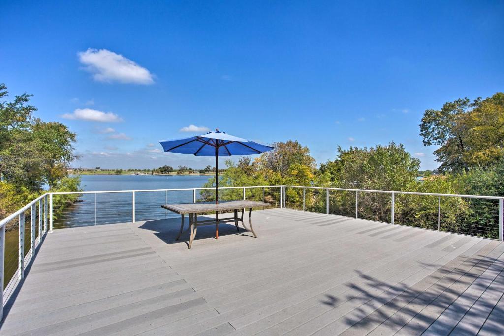 a wooden deck with a table and an umbrella at Lake Granbury Getaway! Family Home w/ Deck & Games in Granbury