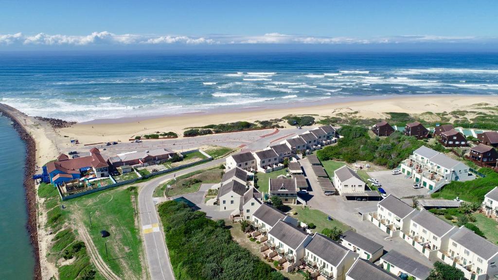 an aerial view of a beach with houses and the ocean at 39 Settler Sands Beachfront Accommodation Sea and River View in Port Alfred