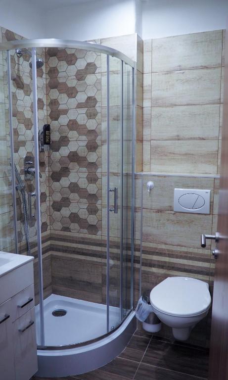 a bathroom with a shower and a toilet at Hotel Sýkora in Křivoklát