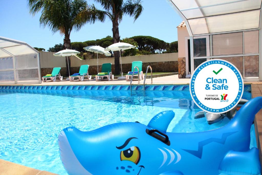a pool at a resort with a blue shark in the water at Villa Fonte Santa in Quarteira