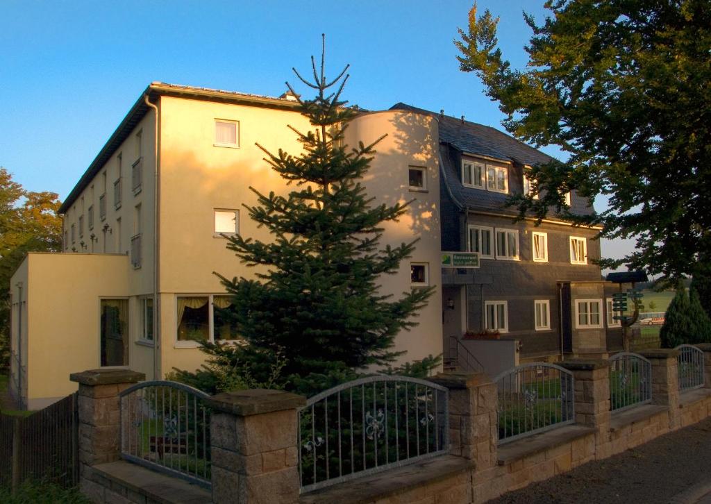 una casa con un árbol de Navidad delante de ella en Hotel Haus Oberland en Masserberg