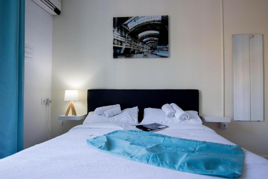 - un lit blanc avec une couverture bleue dans l'établissement B&B - El Magnanimo, à Valence
