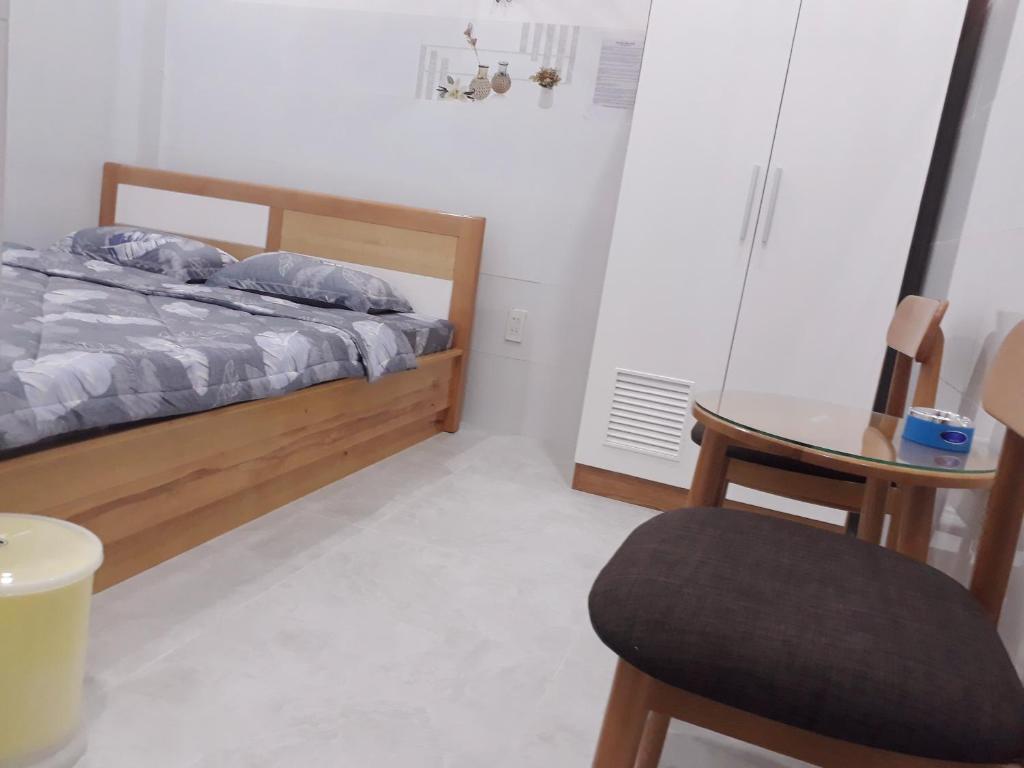 a bedroom with a bed and a chair and a table at Nhà nghỉ 89 in Phan Thiet