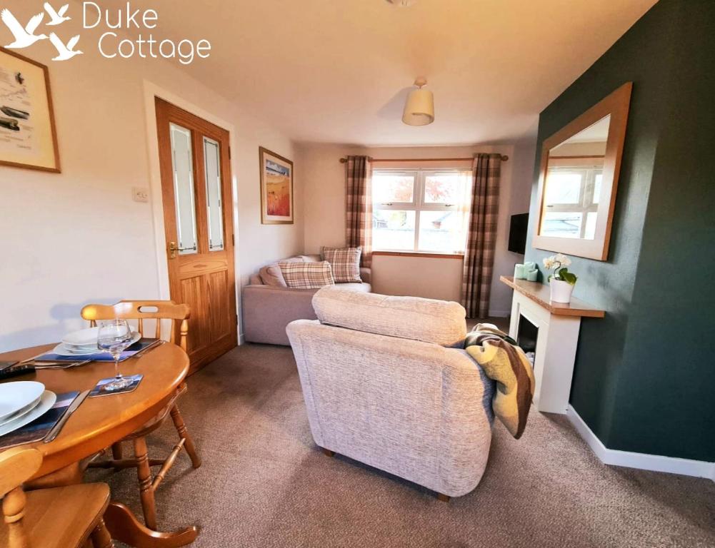 a living room with a couch and a table at Duke Cottage in Fochabers