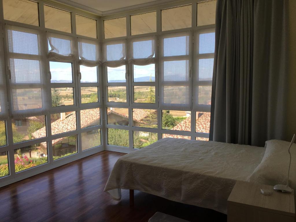 a bedroom with large windows and a bed in front thereof at Villa Argomaniz in Argómaniz