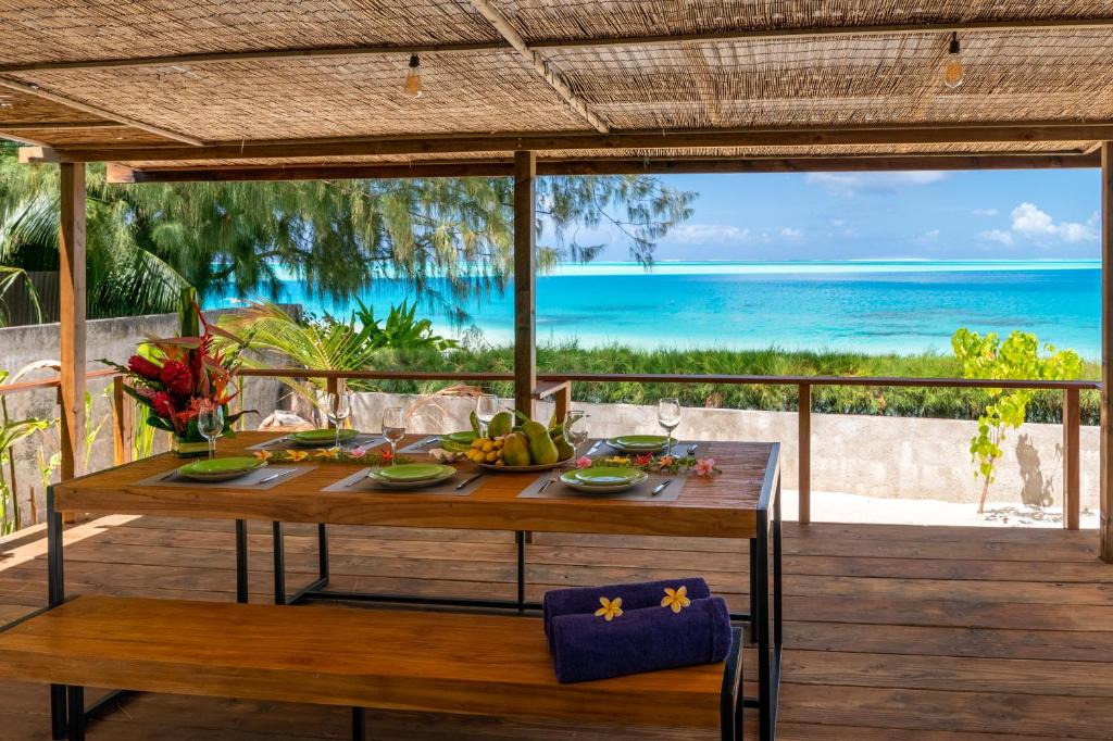 a table on a deck with a view of the ocean at Matira Sandy Home 658 DTO-MT in Bora Bora