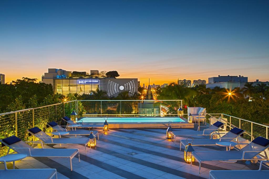una terraza en la azotea con tumbonas y una piscina en Kaskades Hotel South Beach, en Miami Beach
