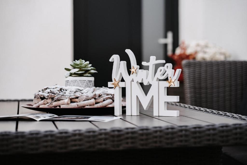 圣迈克尔隆高Dalila Appartements的一张桌子上放着一块牌子，上面写着“冬季”。