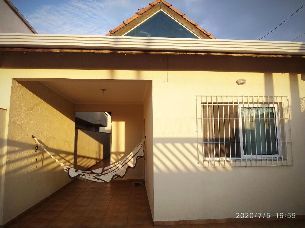 a house with a porch with a hammock outside of it at Casa KAIS Peruíbe in Peruíbe