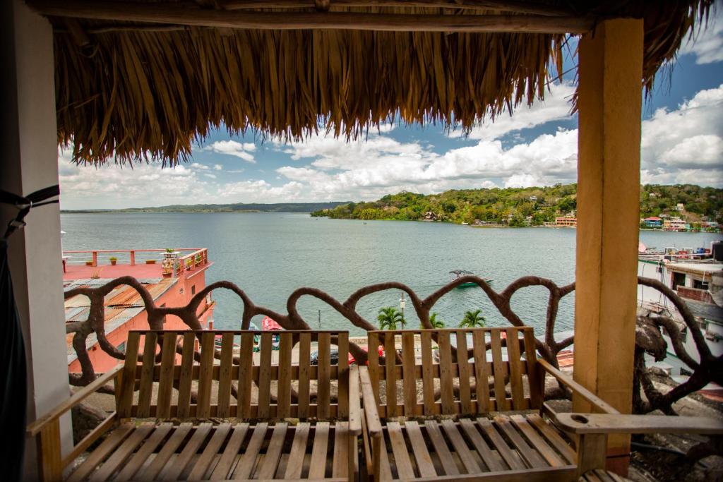 eine Bank auf einer Veranda mit Blick auf einen Wasserkörper in der Unterkunft Hotel Aurora in Flores