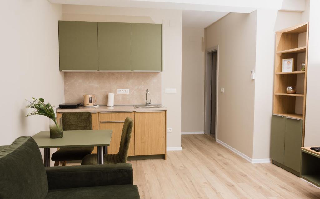 een woonkamer met een tafel en een keuken bij Urban Residence Apartments in Mostar