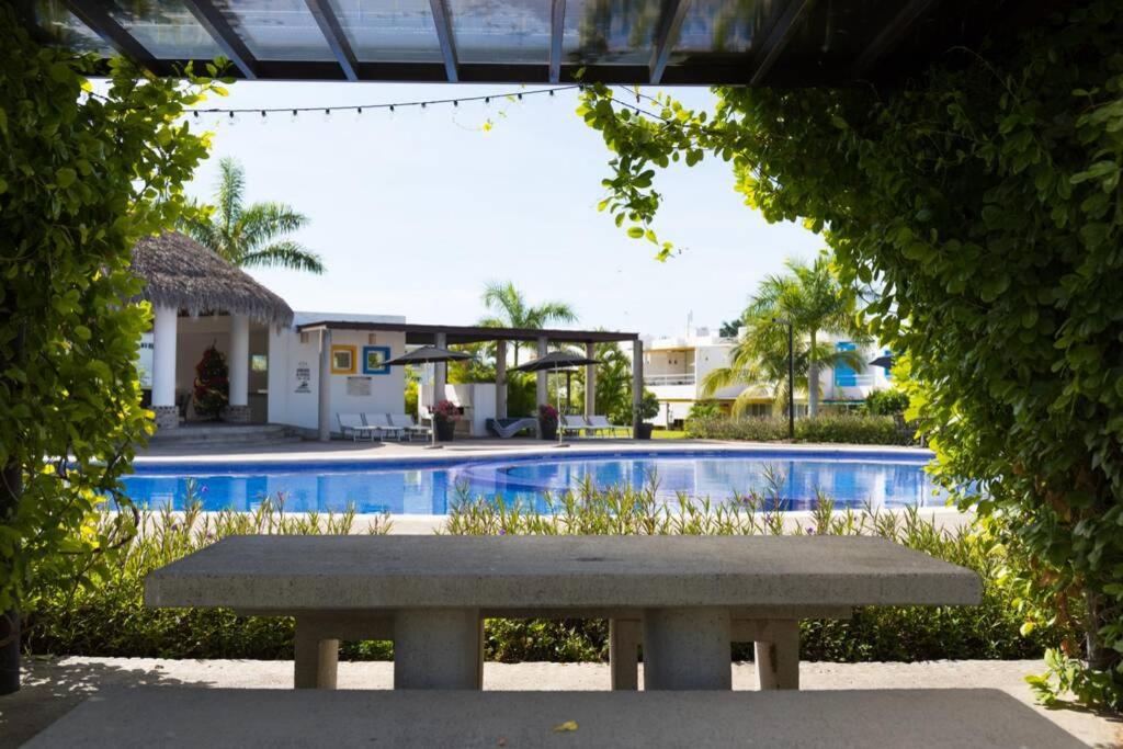 a bench sitting in front of a swimming pool at Casa STB01 con Alberca a 5 min de Nuevo Vallarta in Mezcales