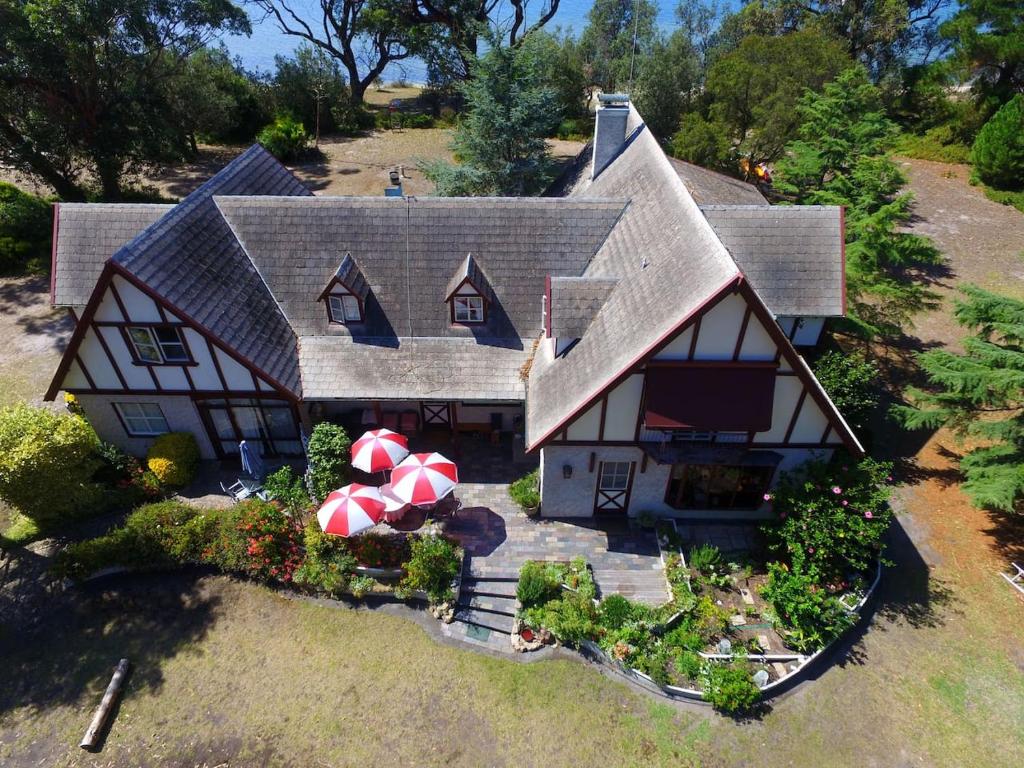 an aerial view of a house with two umbrellas at Swan Cove Beachfront in Raymond Island