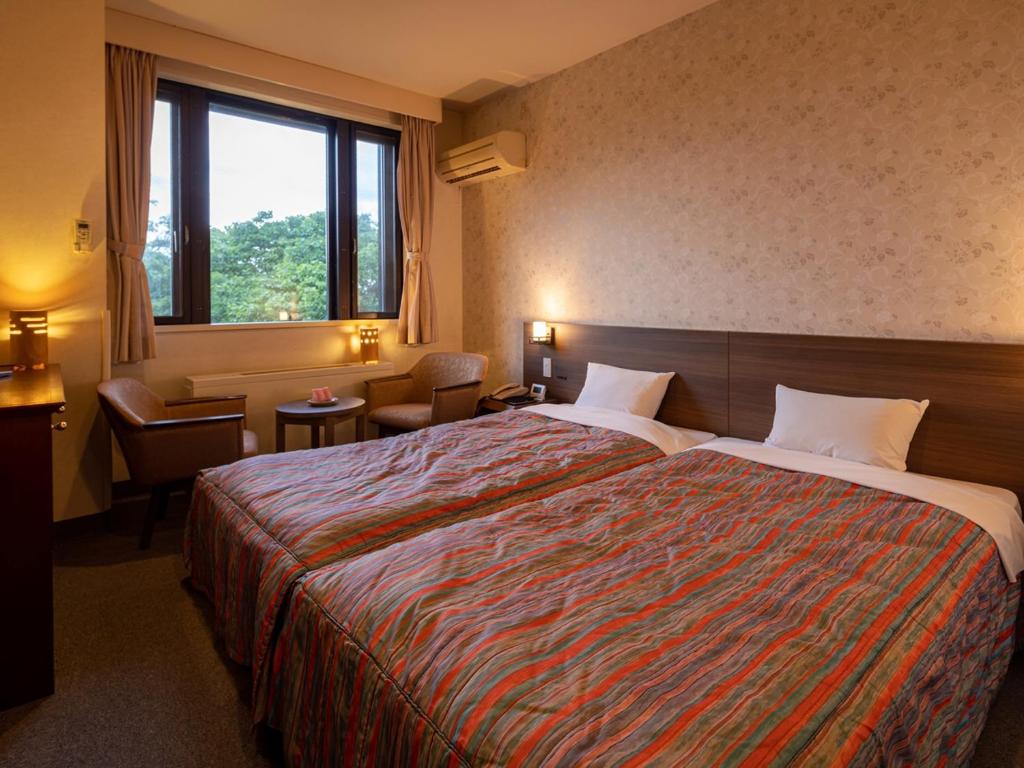 Postel nebo postele na pokoji v ubytování Apikogen Mori no Hotel