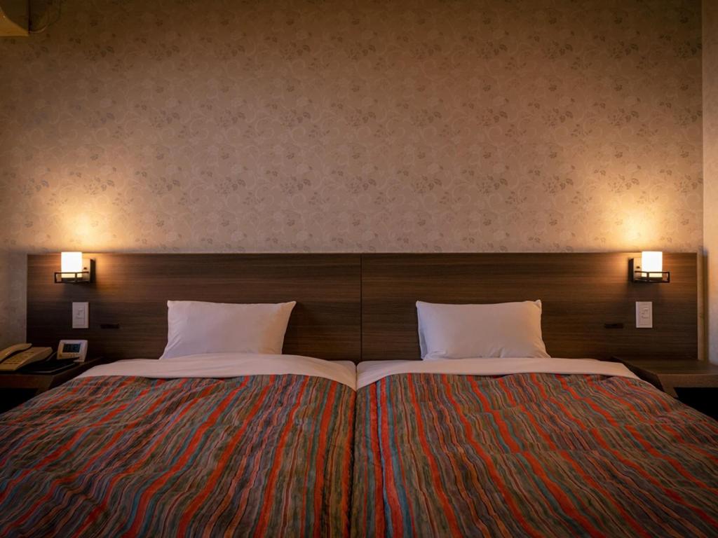 Postel nebo postele na pokoji v ubytování Apikogen Mori no Hotel