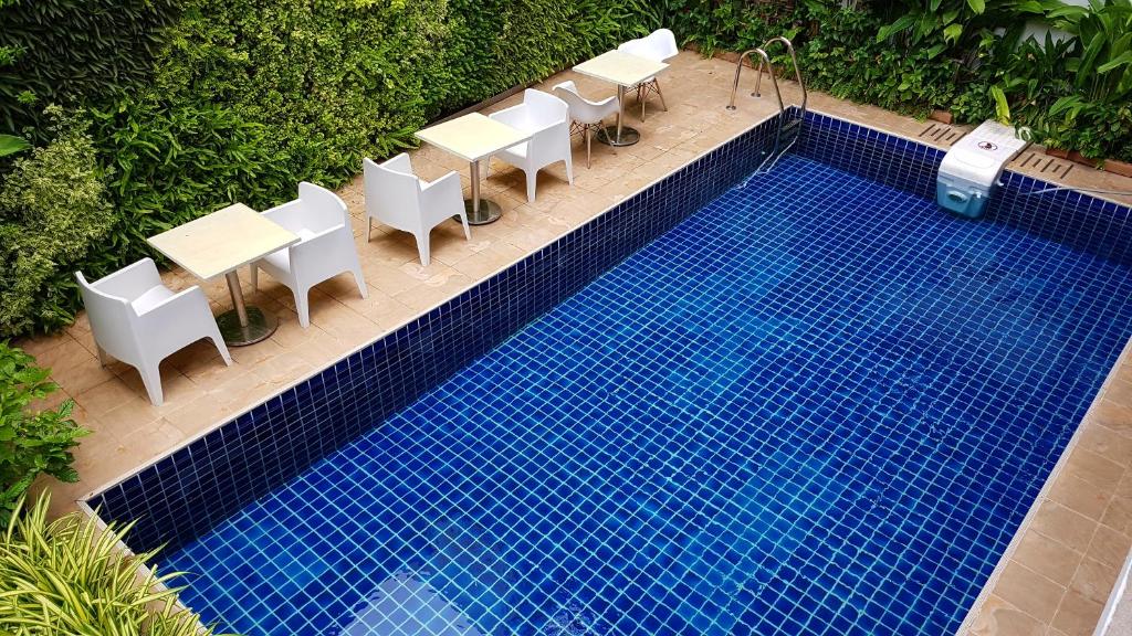 uma vista superior de uma piscina com mesas e cadeiras em Dinsomon Hotel em Bangkok