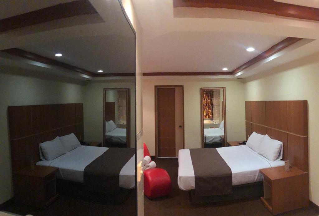 a hotel room with two beds and a mirror at HOTEL ORION in Mexico City