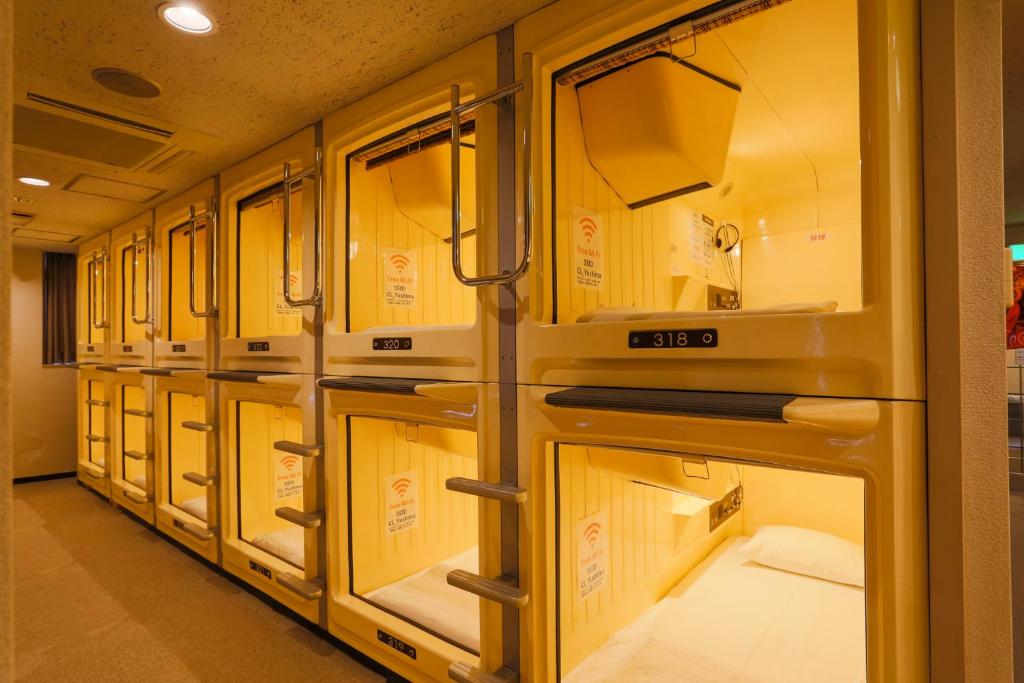 a row of beige ovens lined up in a row at Capsule Land Yushima (Male Only) in Tokyo