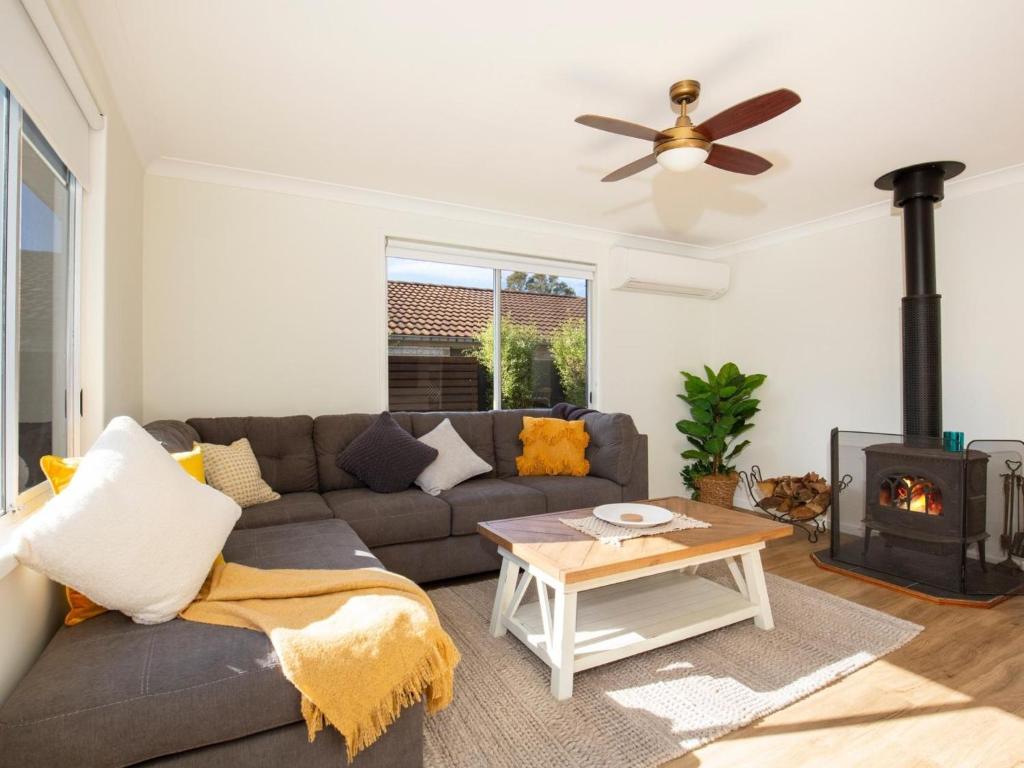 a living room with a couch and a wood stove at Pagoda at Culburra I Pet Friendly I Newly Renovated in Culburra Beach