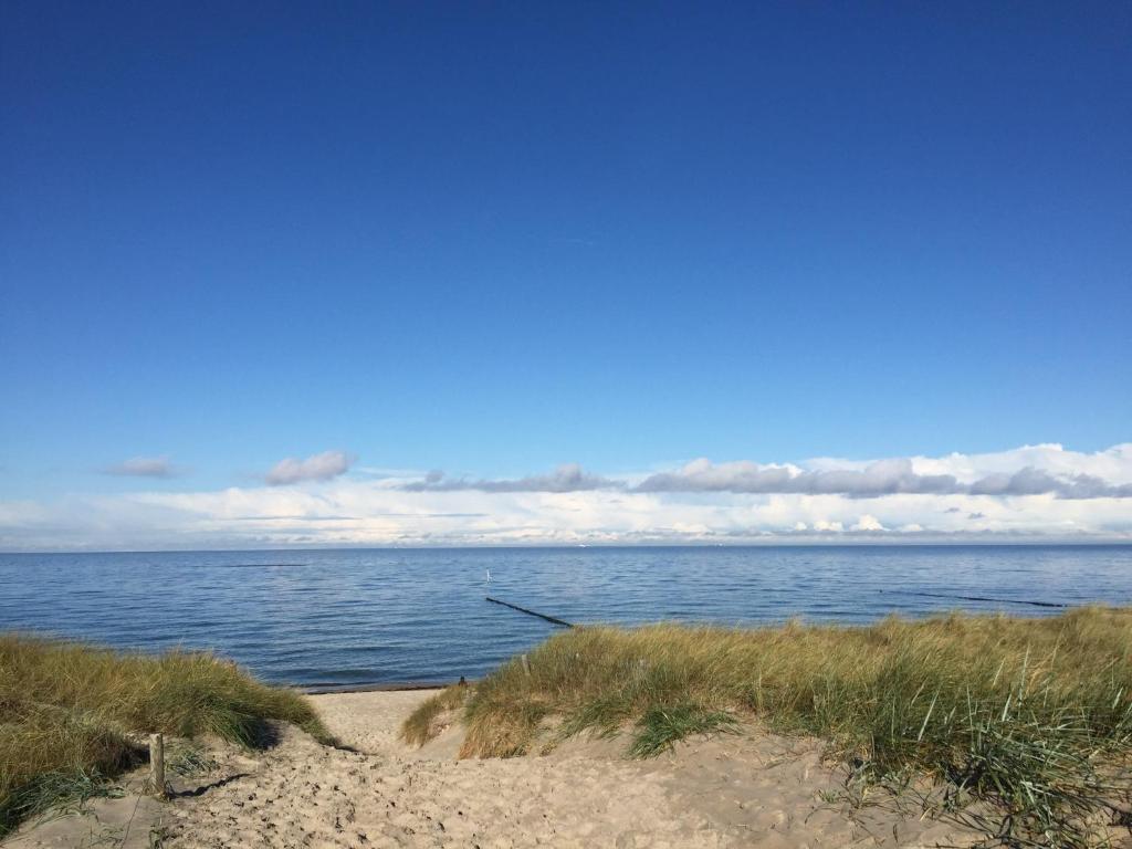 un camino a la playa con el océano en el fondo en Die kleine Acht - direkt am Strand, en Dierhagen