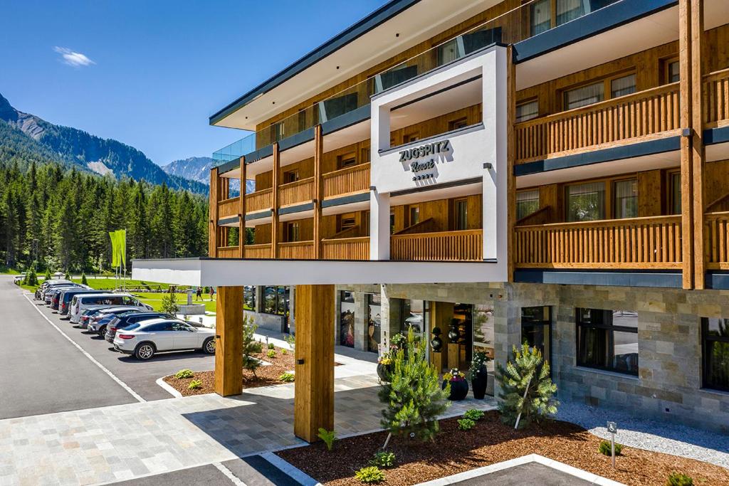 a large building with a parking lot in front of it at Zugspitz Resort in Ehrwald