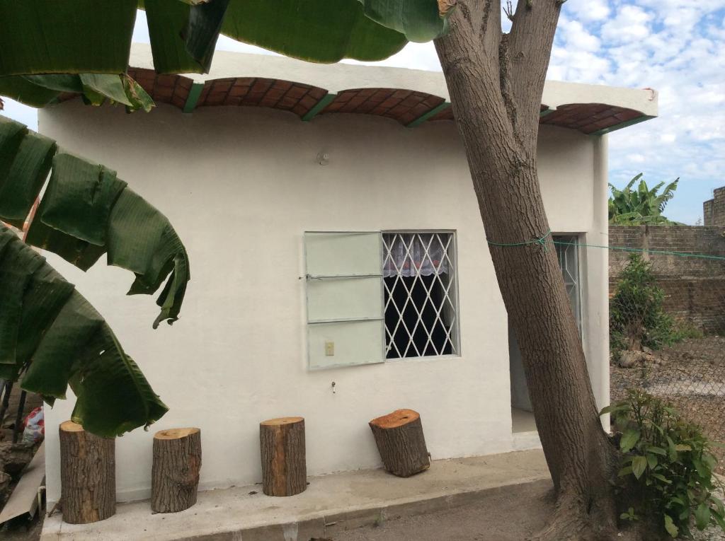 una casa bianca con una finestra e tre tronchi di Casa de descanso en Santa Cruz a Tepic