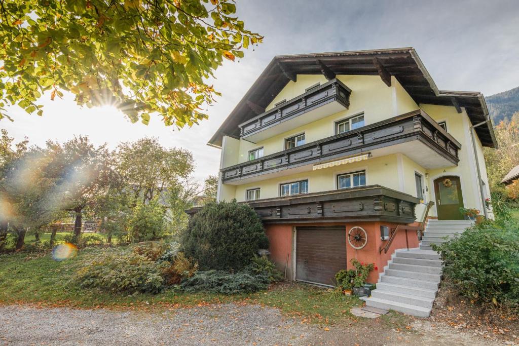 a yellow house with a wooden roof at NaturparkResort Apartment Hörmann in Ardning