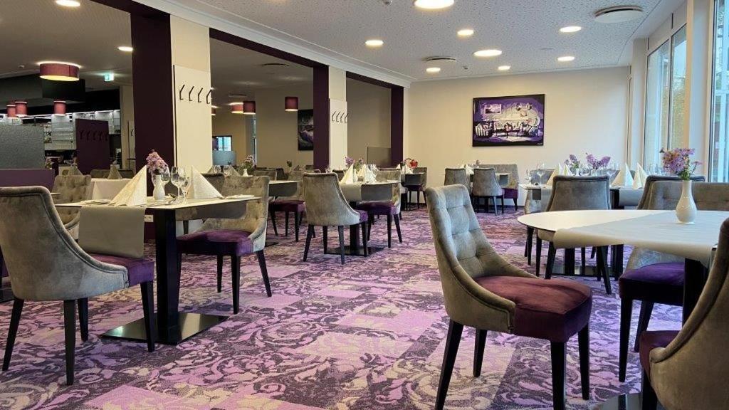 un comedor con mesas y sillas en un restaurante en Hotel am Schloß Apolda en Apolda