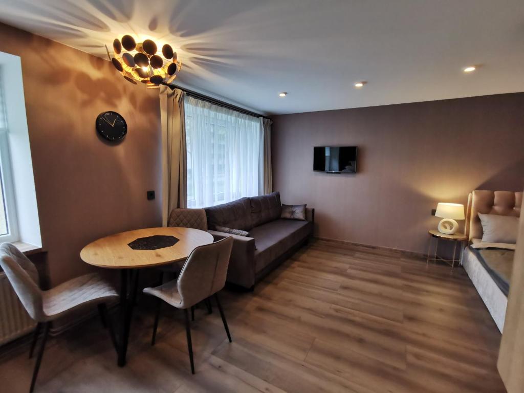 uma sala de estar com um sofá e uma mesa em Cool Apartments em Liepāja