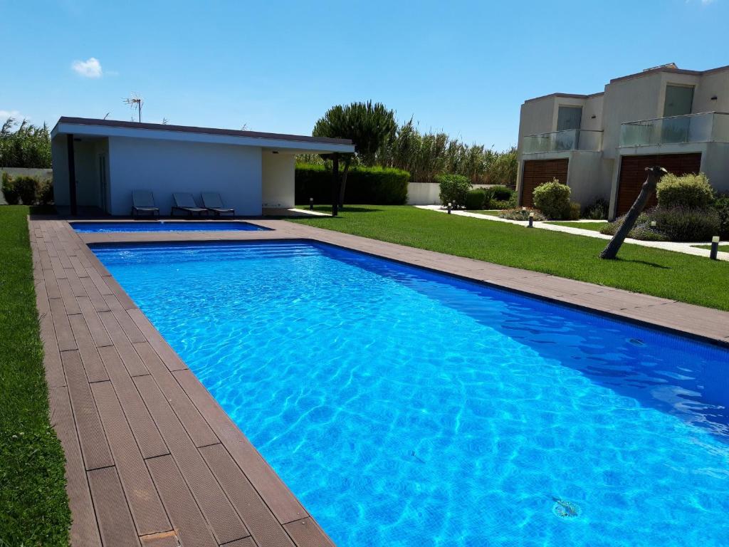 a large blue swimming pool in front of a house at Sea Sagres in Sagres