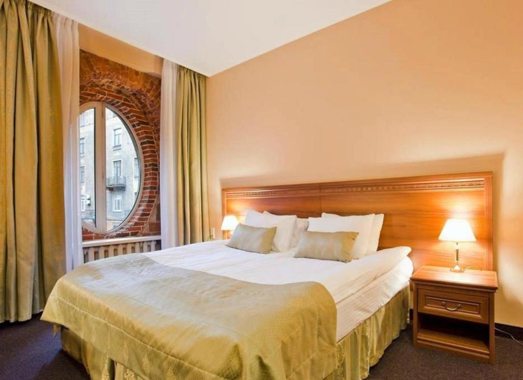 a hotel room with a large bed and a window at Arkada Hotel in Saint Petersburg