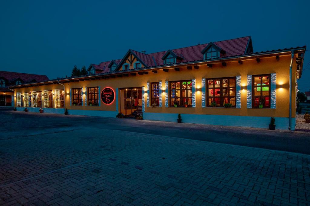 a building with lights on the side of it at night at Radics Panzió Étterem és Pihenő Központ in Letenye