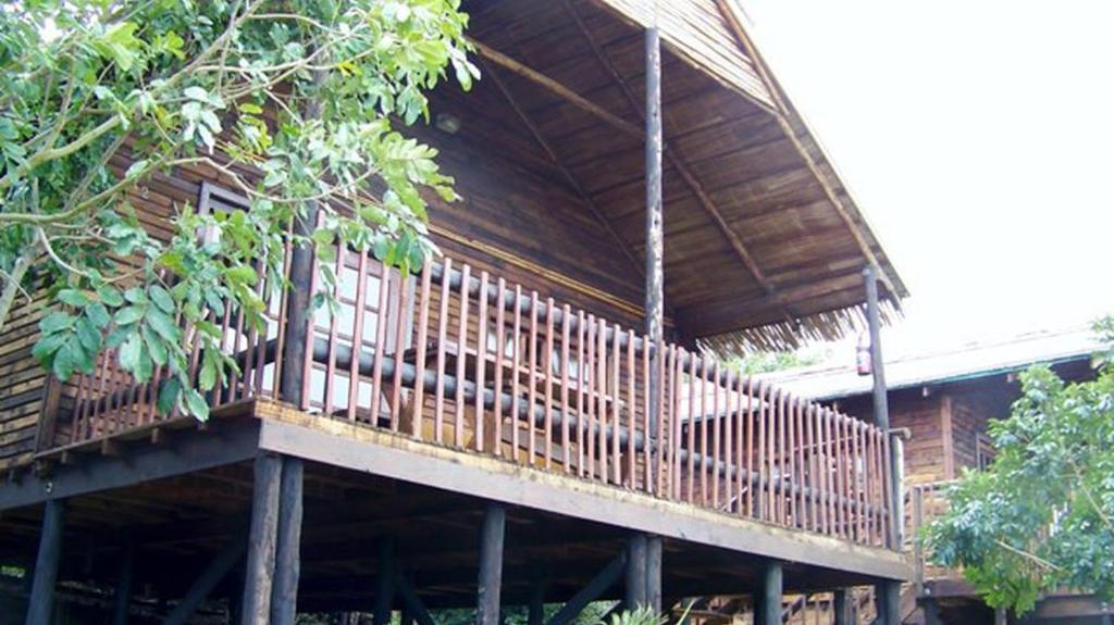 a large wooden deck on a house with trees at MOZBEVOK Coconut View Resort in Ponta do Ouro